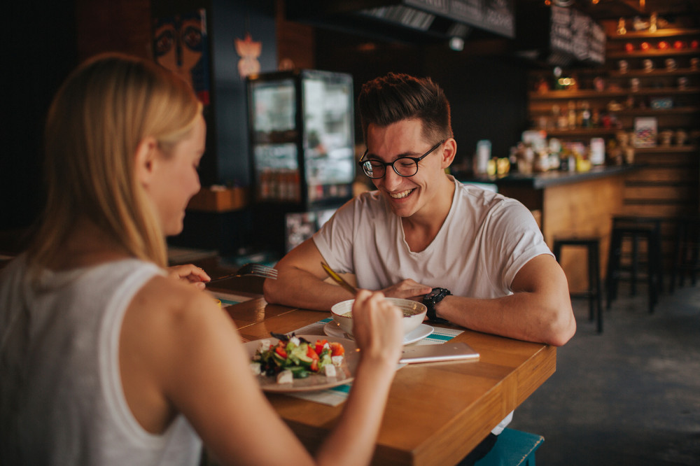 Zwei junge attraktive Singles sitzen bei einem Date im Café.